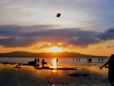 Stunning aerial view of Radhanagar Beach on Havelock Island, featuring crescent-shaped white sands, dense green rainforest, and vibrant blue ocean water.